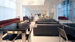 A spacious lobby with a modern design, featuring a reception desk, seating areas, and large windows. - West All Suite Boutique Ashdod (Ashdod)