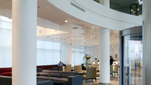 A spacious lobby with high ceilings, a central seating area, and a glass elevator. - West All Suite Boutique Ashdod (Ashdod)
