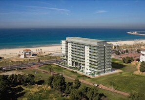 A modern multi-story hotel with a flat roof, located near a beach with a clear view of the ocean. - Brown Seaside Ashdod (Ashdod)