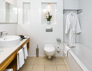 A modern bathroom with a sink, toilet, and bathtub. There is a towel rack and a mirror above the sink. - Brown Seaside Ashdod (Ashdod)