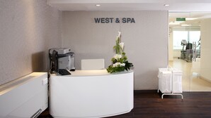 A reception desk with a computer, a chair, and a floral arrangement. - Brown Seaside Ashdod (Ashdod)