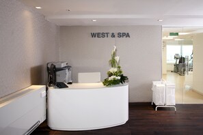 A reception desk with a computer, a chair, and a floral arrangement. - Brown Seaside Ashdod (Ashdod)