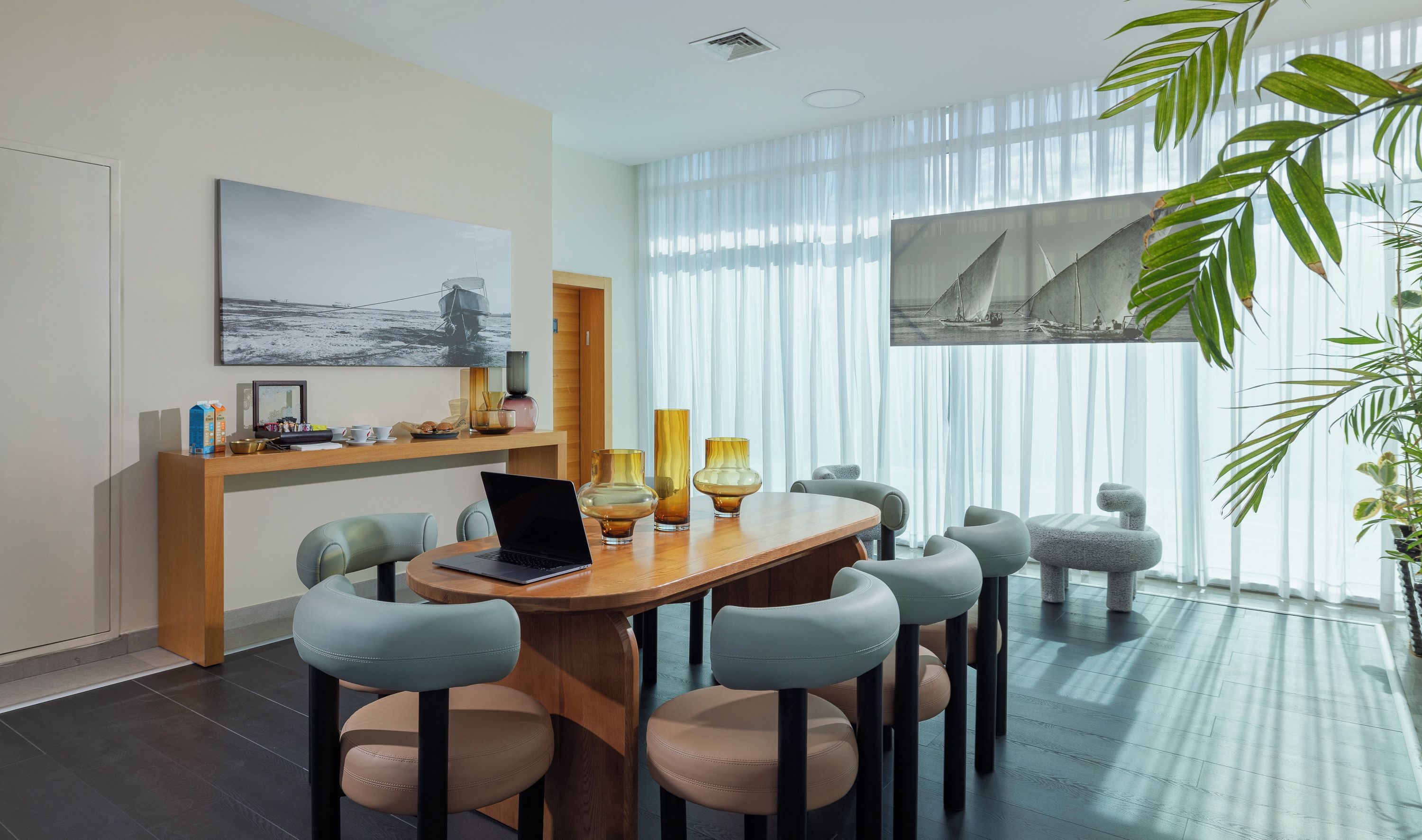 Un comedor moderno con una mesa redonda, seis sillas y una computadora portátil.