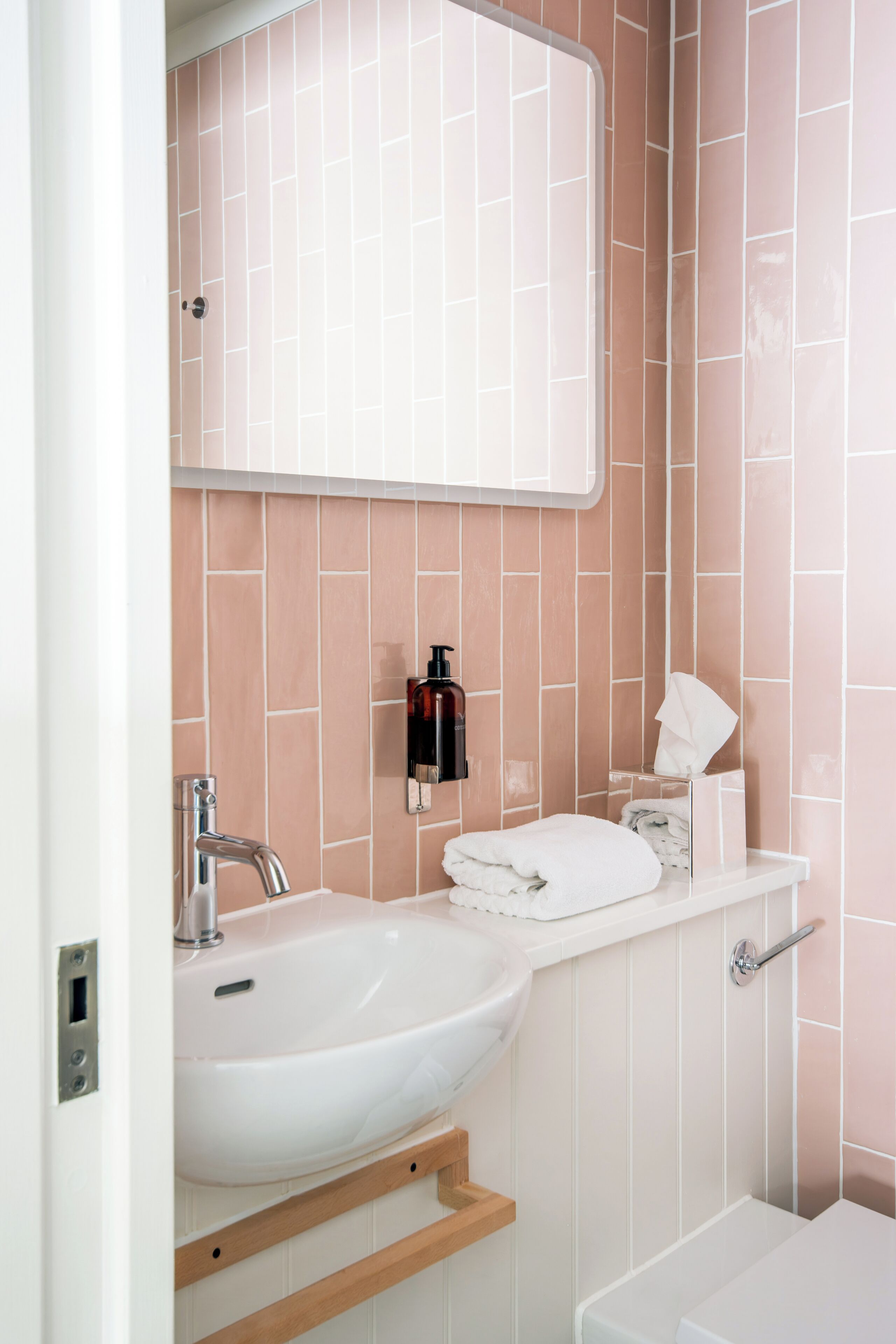 Un baño con lavamanos blanco, un espejo y un inodoro.
