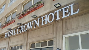 The exterior of the Royal Crown Hotel with large windows and a prominent sign. - Royal Crown Hotel (Alexandria)