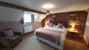 A bedroom with a bed, a chair, a radiator, and a window.