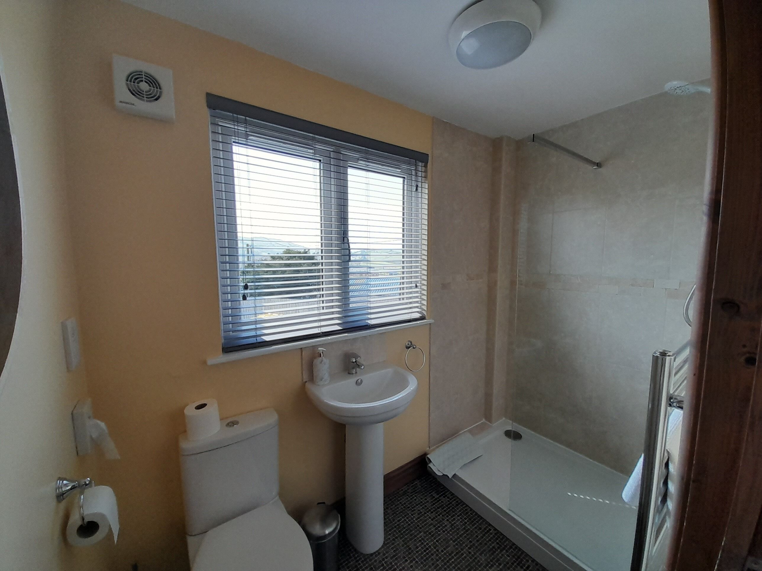 Un baño con inodoro, lavabo y ducha.