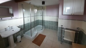 A bathroom with a shower, sink, and toilet.