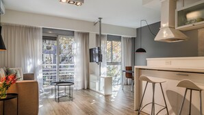 A modern kitchen with a dining area, a sofa, and a TV. - Color Botanico (Buenos Aires)