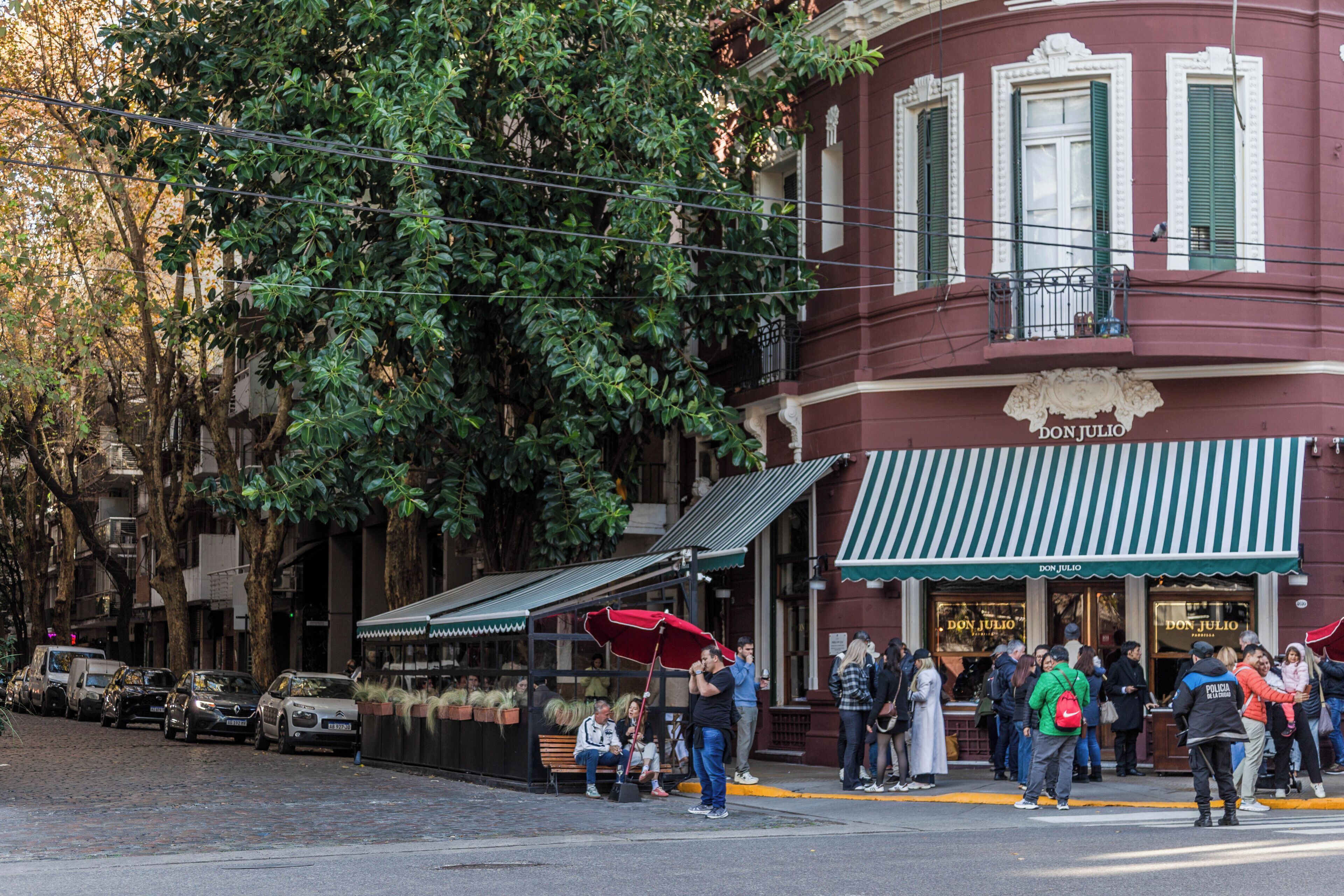 A street scene with a building labeled 'DON JULIO' and a sidewalk cafe.