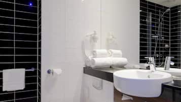 A modern bathroom with a toilet, sink, and shower.