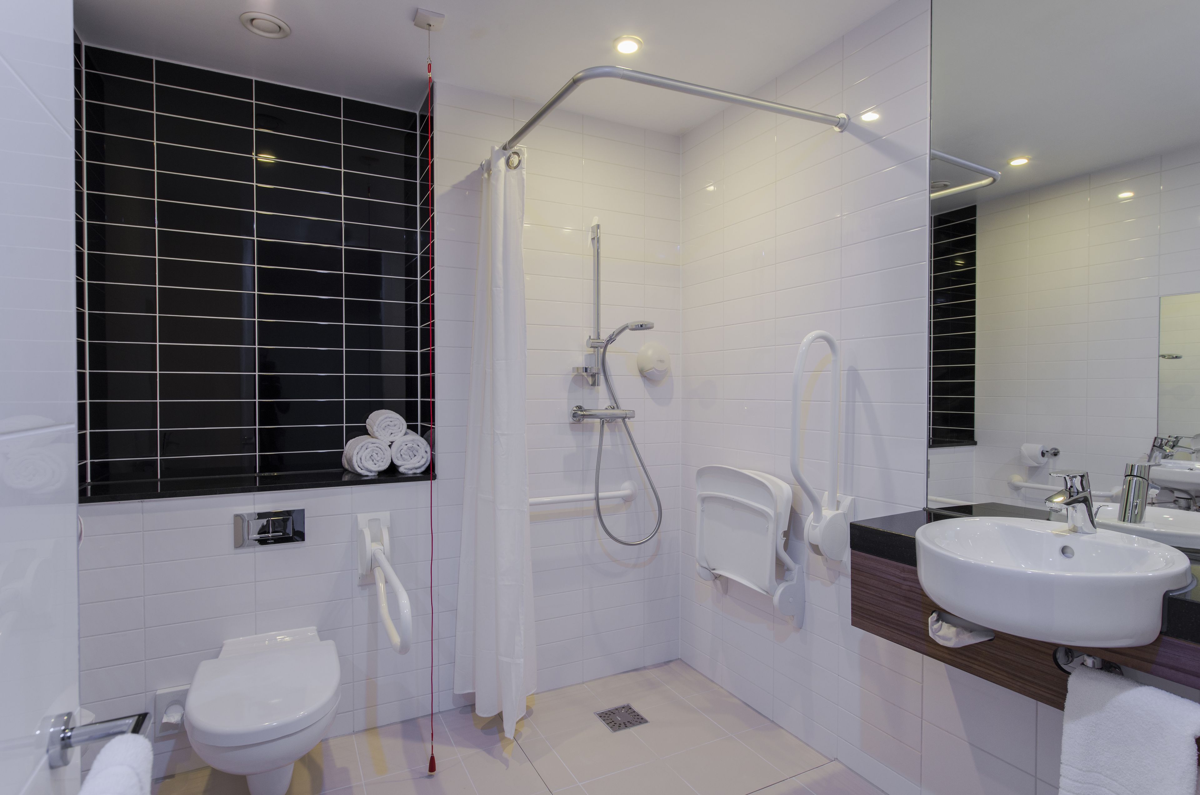 A modern bathroom with a shower, toilet, and sink.
