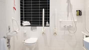 Een moderne badkamer met een wit toilet, een wastafel, een douche en een raam met een zwarte omlijsting.