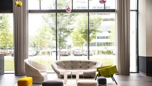 Un hall d’entrée moderne avec un canapé, des poufs et une table basse.