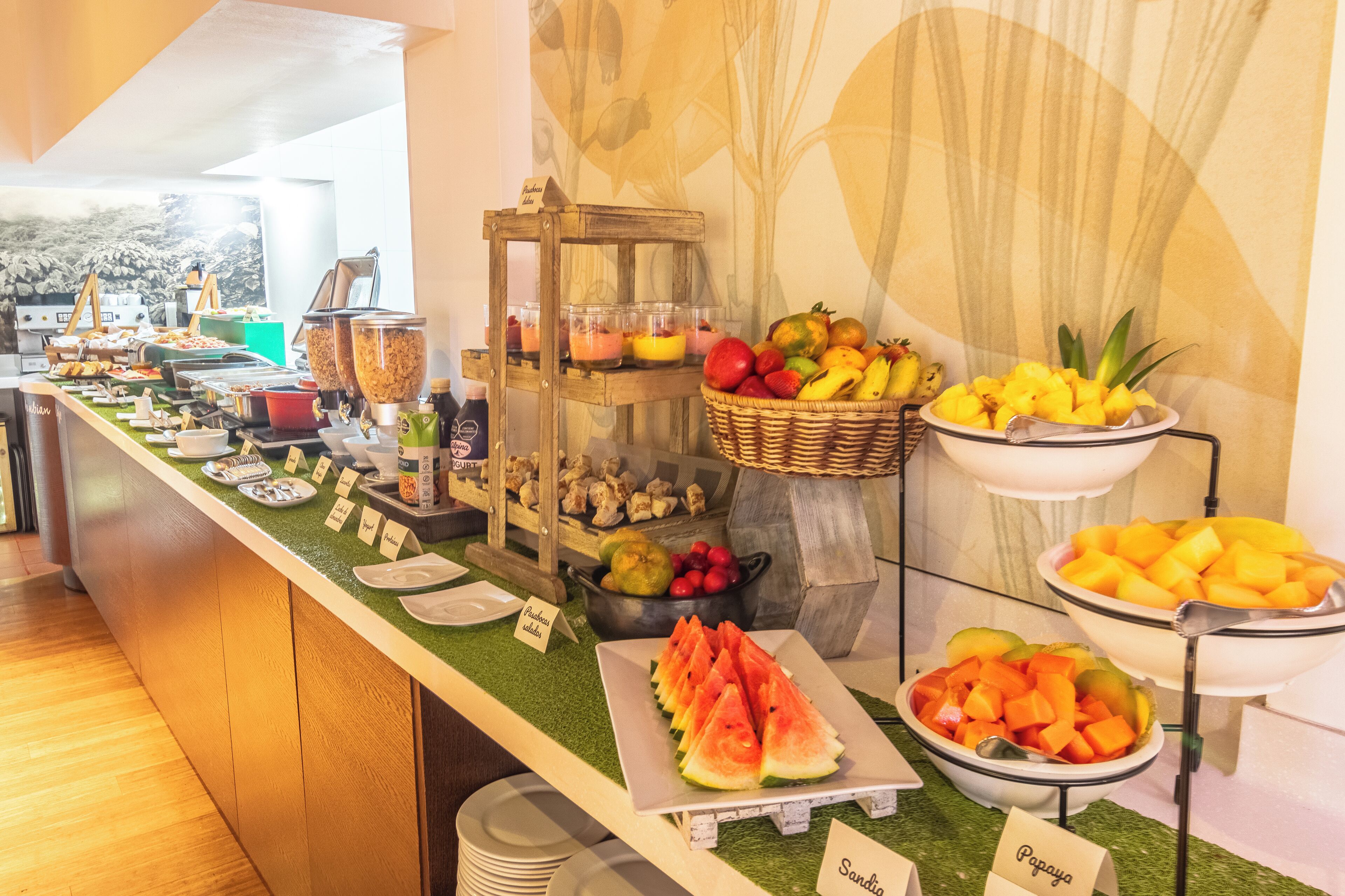 Een buffet met verschillende soorten fruit en gerechten, waaronder watermeloen, papaja en een verscheidenheid aan ander fruit.
