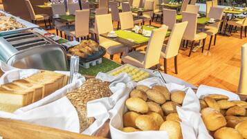 A buffet area with various breads and pastries.