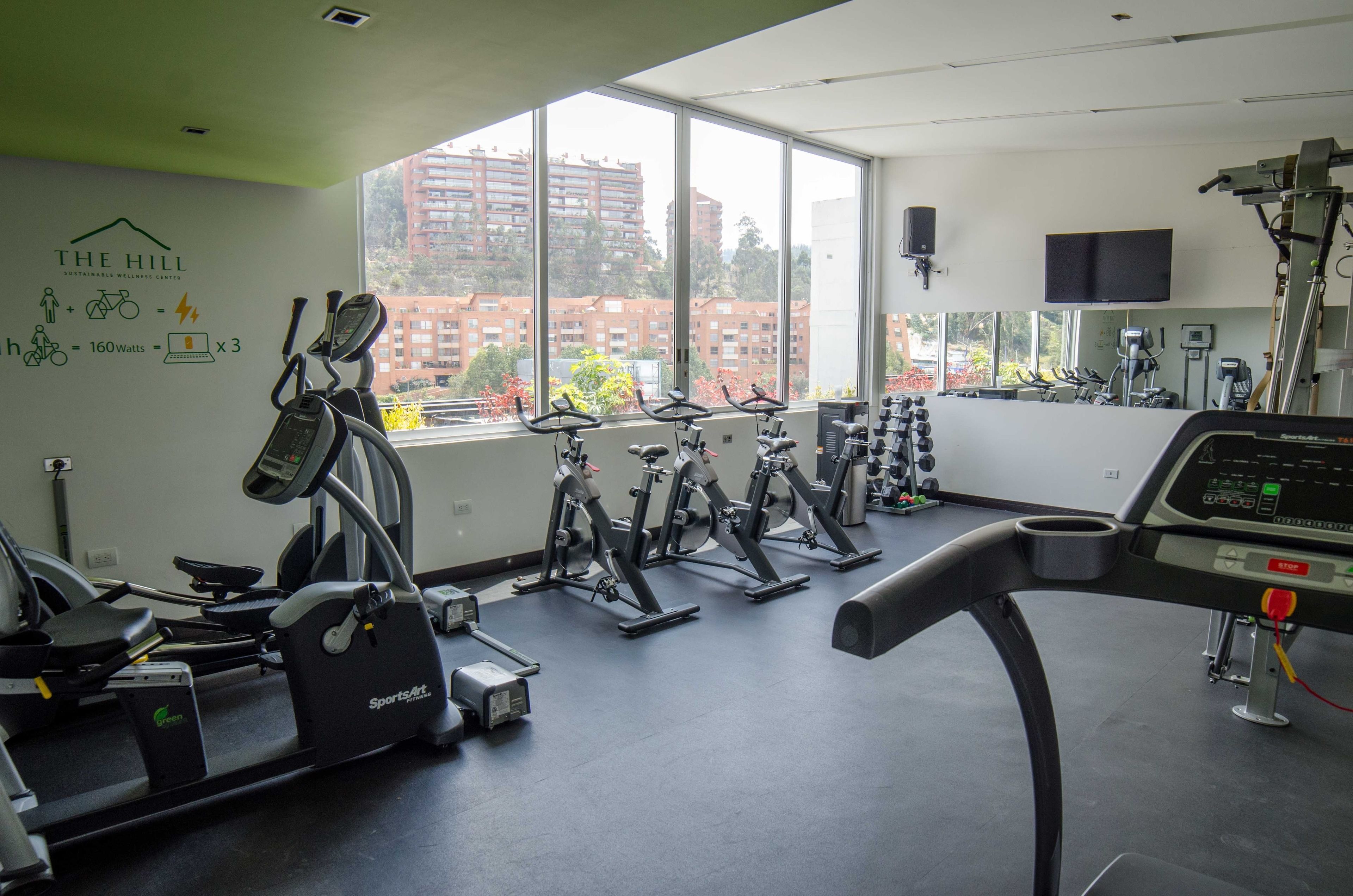 A gym with stationary bikes, treadmills, and weights.