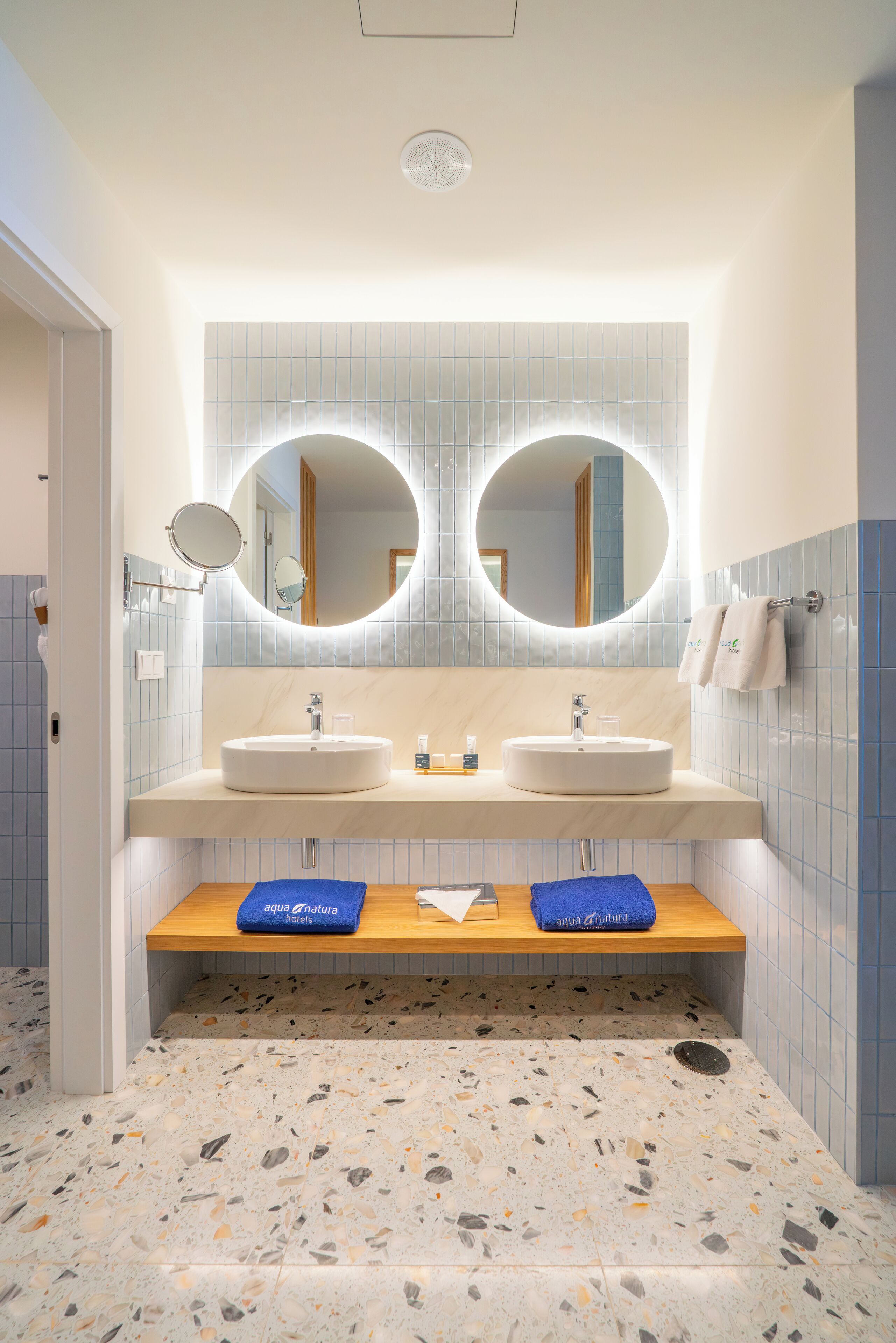 A bathroom with two sinks, a mirror, and a towel rack.