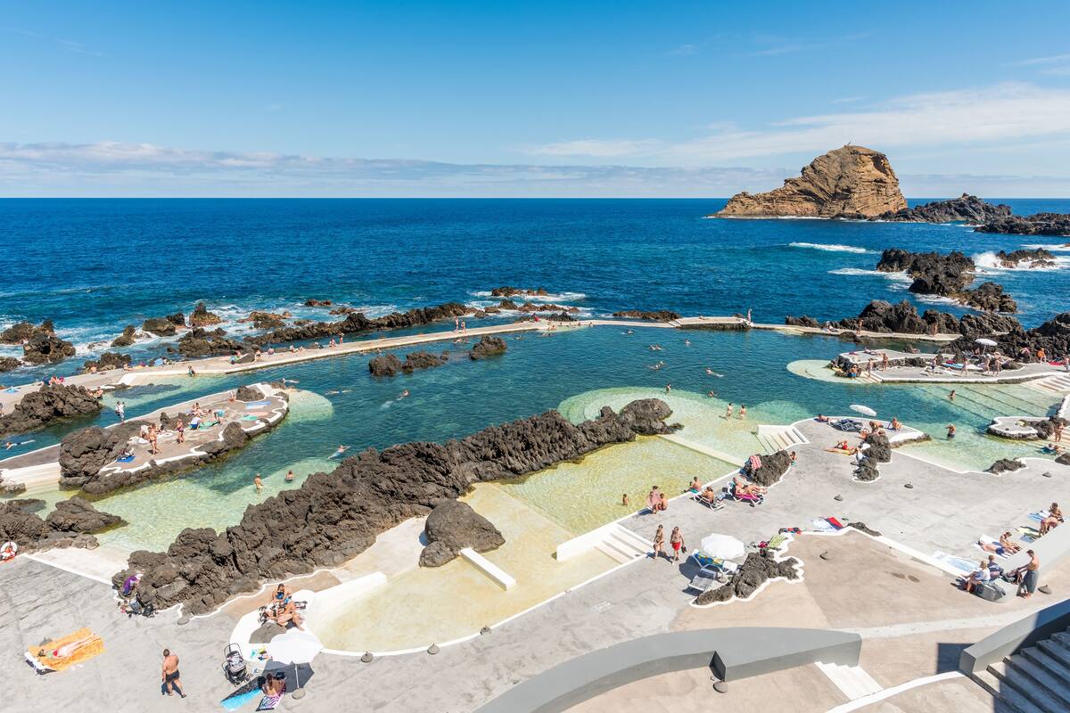 A coastal resort with clear waters, rocky formations, and a sandy beach area.