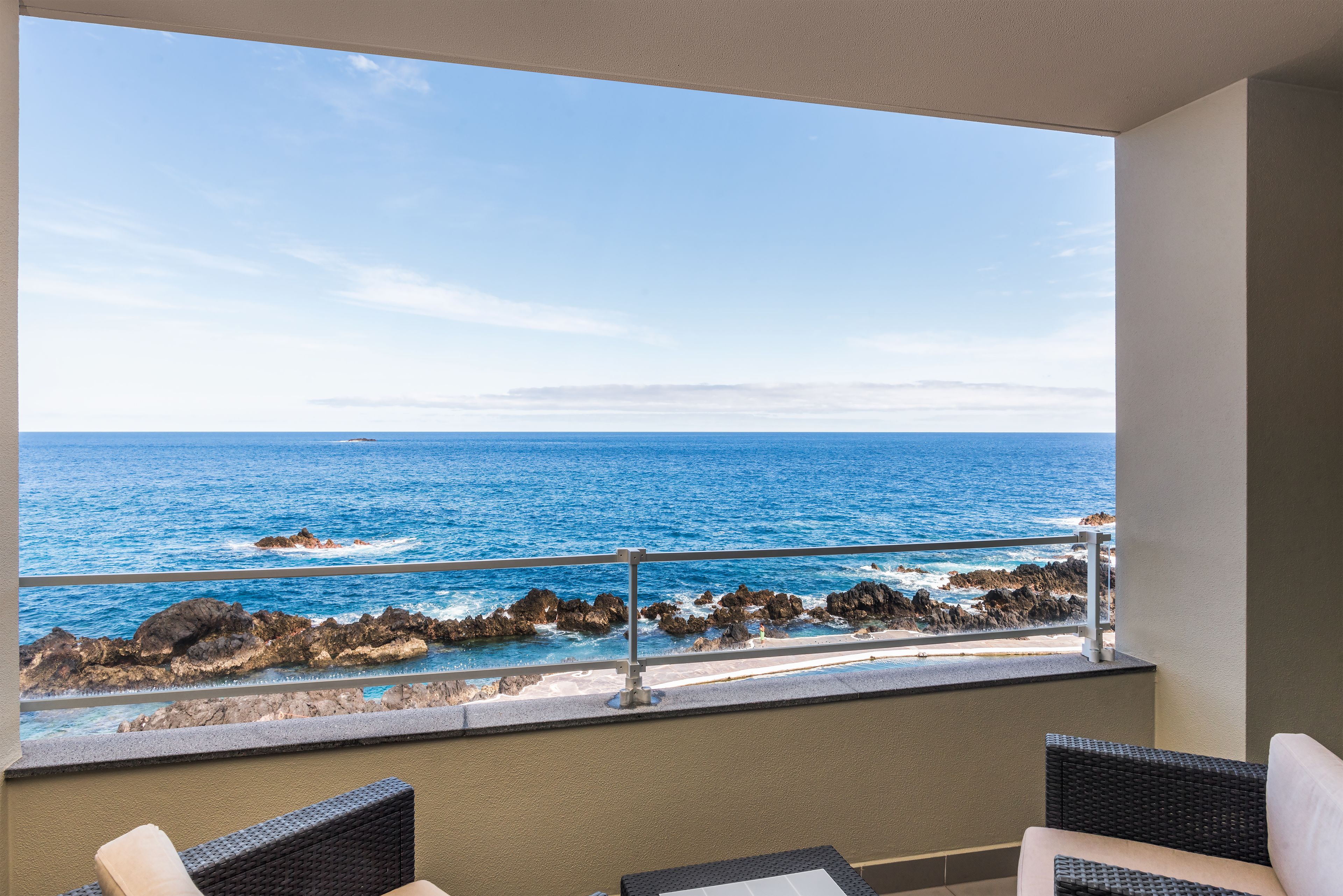 Ein Balkon mit Blick auf das Meer und die felsige Küste.