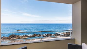 Ein Balkon mit Blick auf das Meer und die felsige Küste.