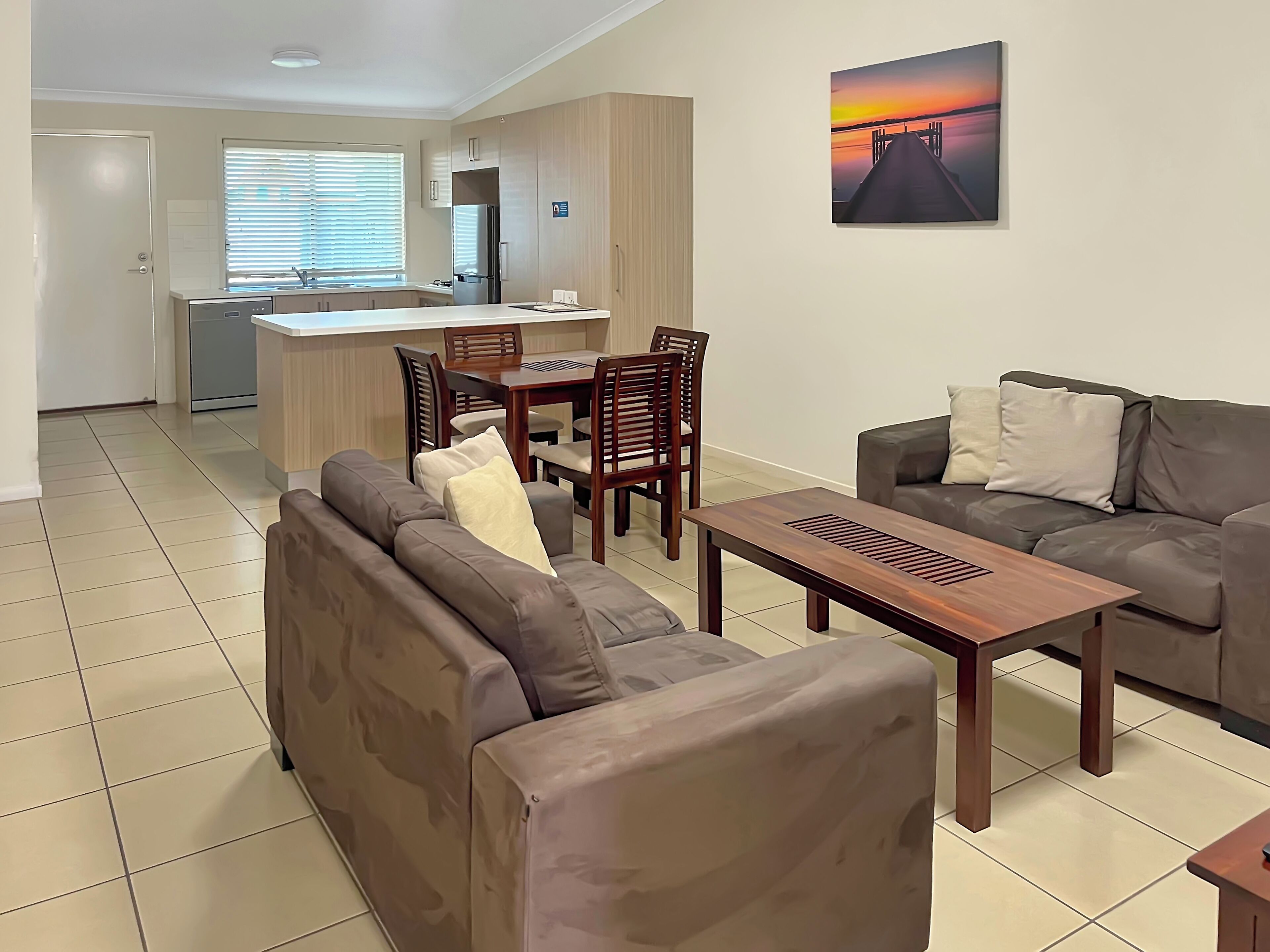 Una sala de estar moderna con un sofá, una mesa de centro y un comedor con sillas y una mesa.