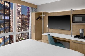 A modern hotel room with a large bed, a desk with a computer, a TV, and a coffee machine. - Hilton Garden Inn New York/Manhattan-Midtown East (New York)