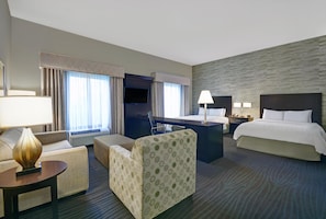 A hotel room with a bed, a desk, a chair, a sofa, and a lamp. - Hampton Inn & Suites Robbinsville (Robbinsville)