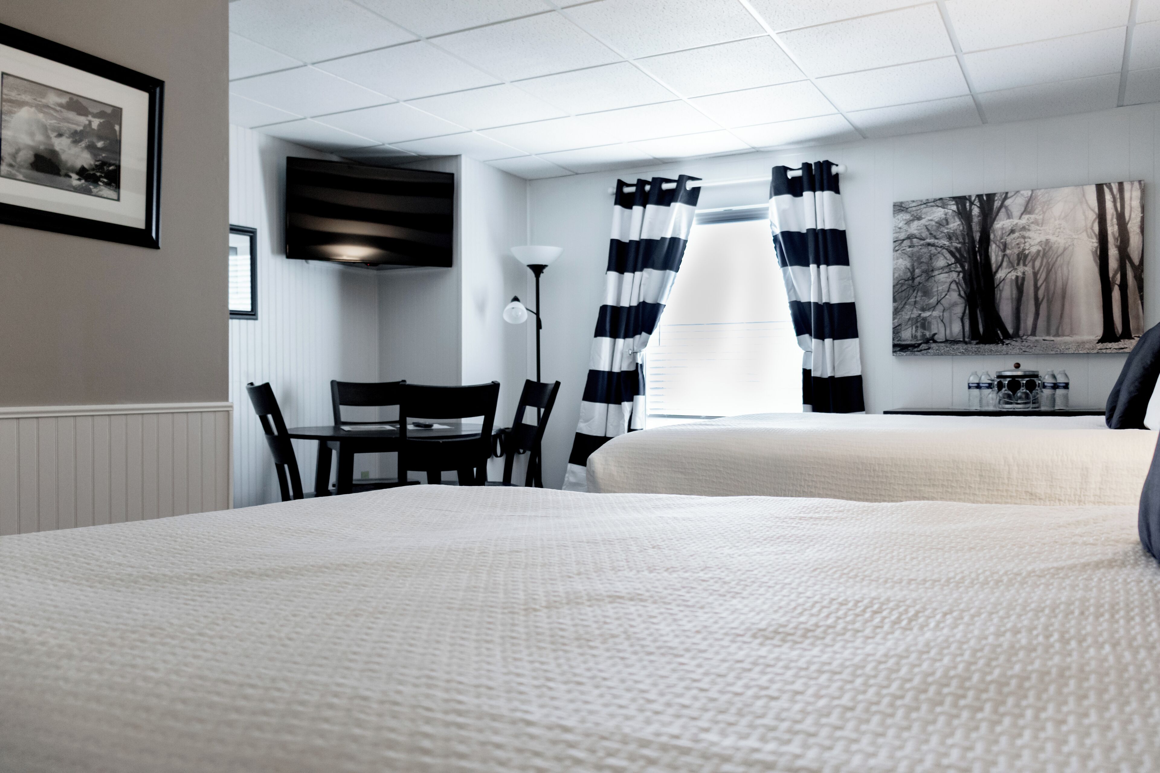Une chambre d’hôtel avec un grand lit, un bureau avec une chaise, une lampe et un tableau au mur.