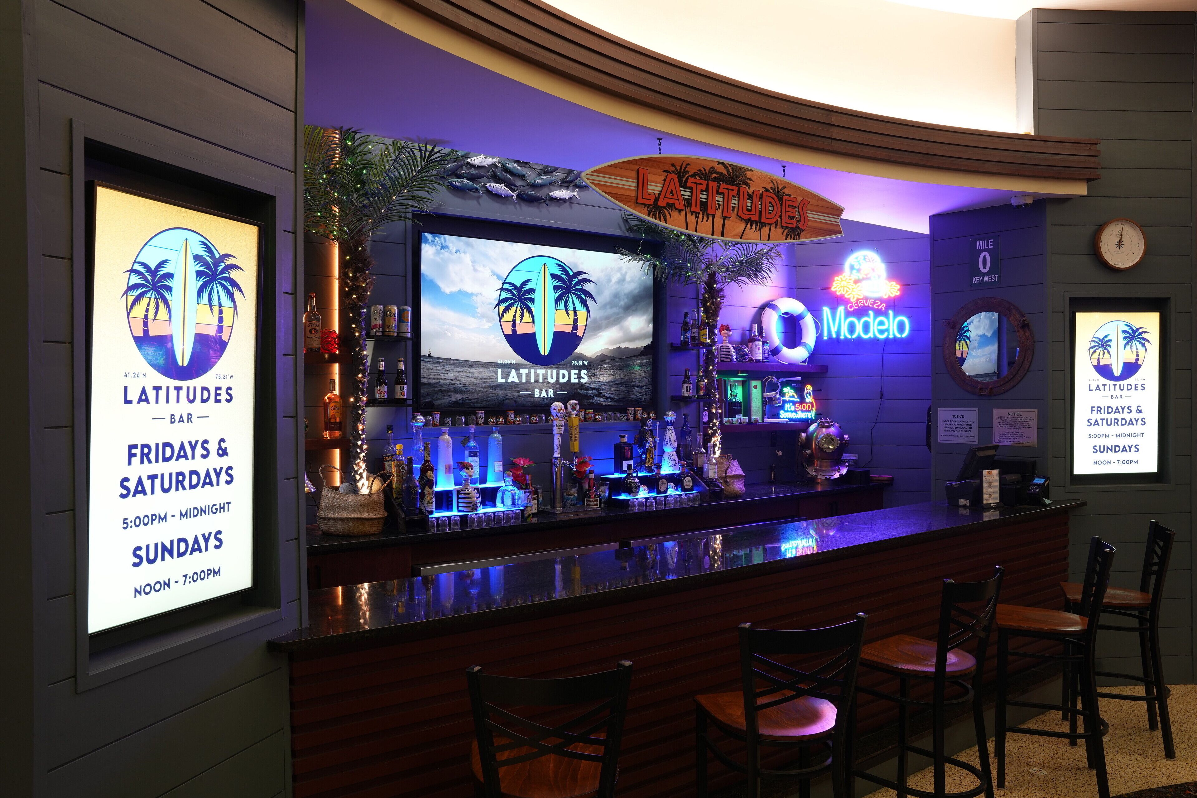 A bar area with a counter, chairs, and various bottles and decorations.