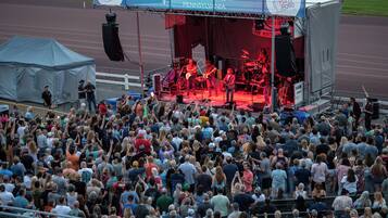 A crowded outdoor event with a stage and a crowd of people.