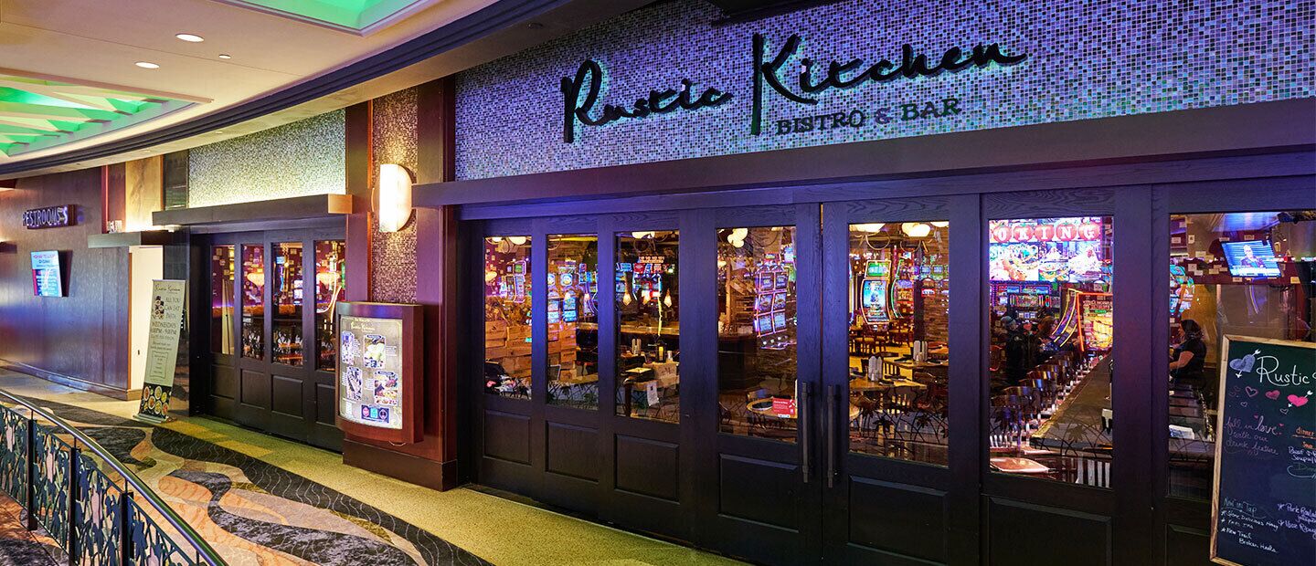 A restaurant with a neon sign, glass doors, and visible arcade games inside.