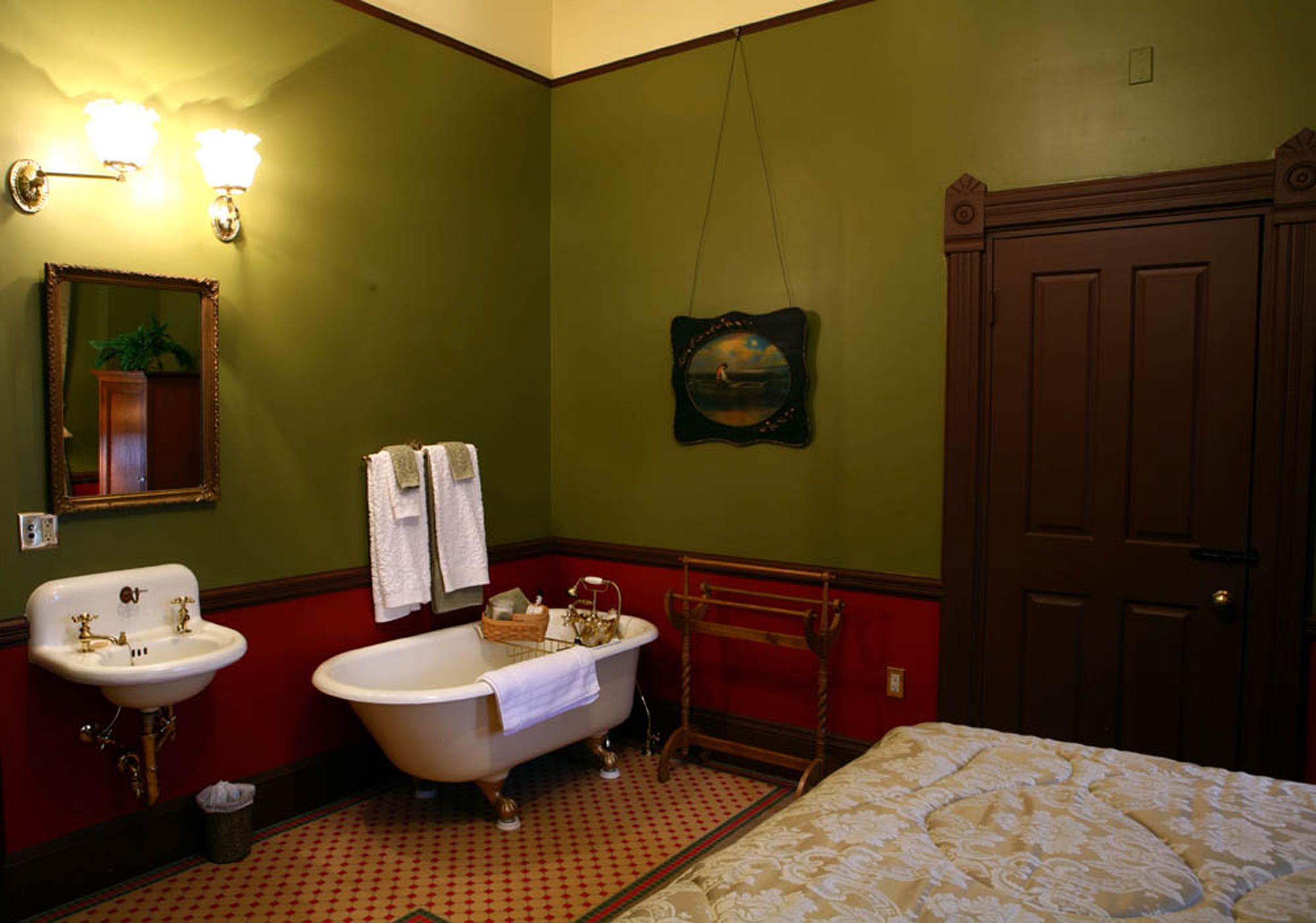 A bathroom with a sink, bathtub, and a wooden door.