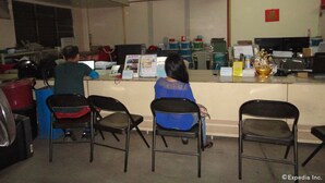A reception area with a counter, chairs, and various informational brochures. - GE Home Residential Inn (Cebu City)