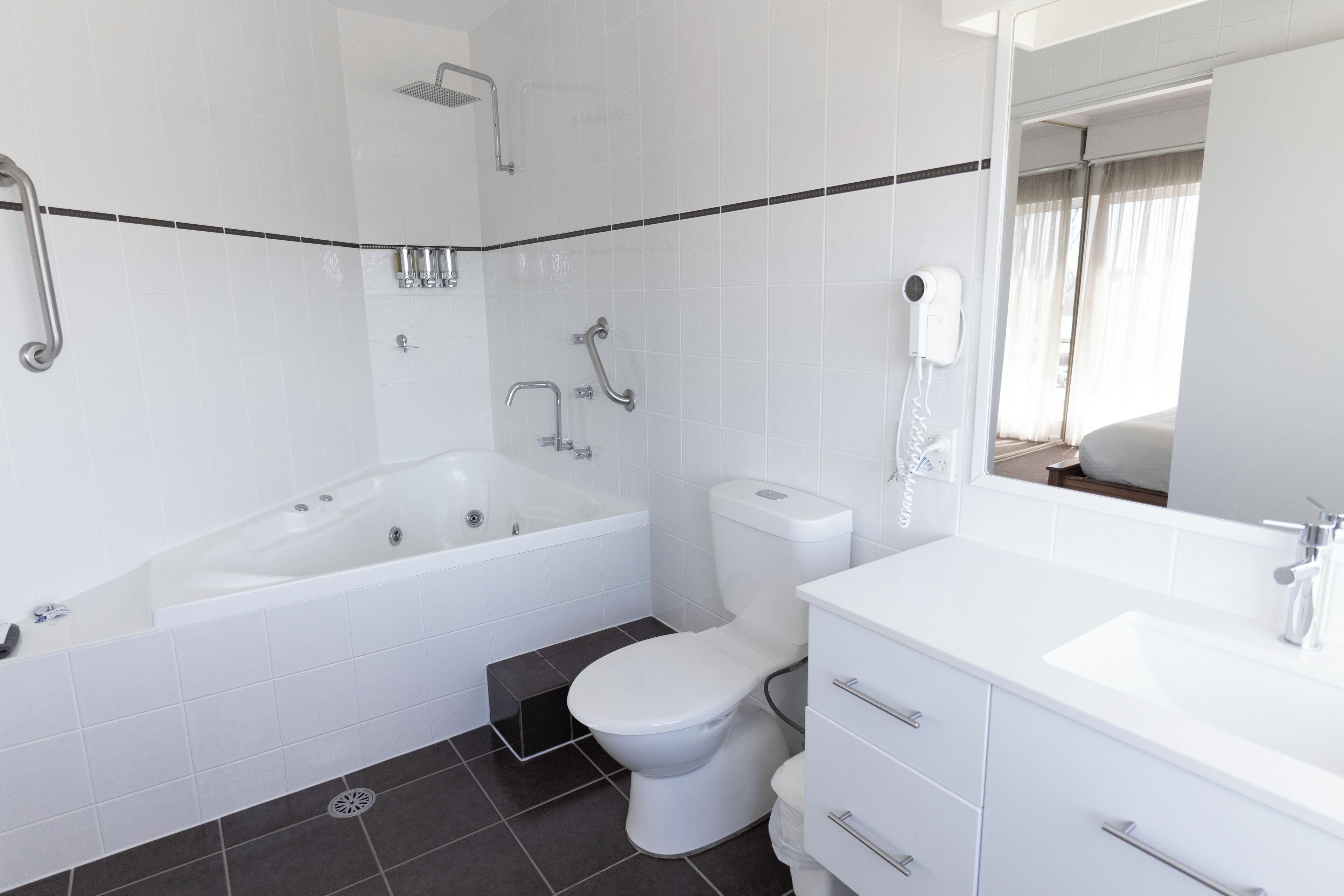 A modern bathroom with a bathtub, toilet, and sink.