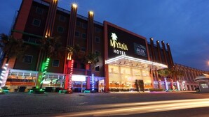 A hotel with a prominent sign, multiple floors, and a well-lit entrance. - Miyana Hotel (Medan)