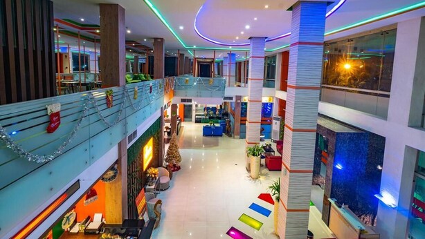 A multi-level hotel lobby with a central staircase, seating areas, and a Christmas tree. - Miyana Hotel (Medan)
