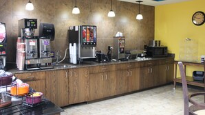 Un coin cuisine équipé d’une machine à café, d’un four à micro-ondes et de divers appareils électroménagers.
