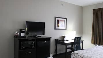 A hotel room with a bed, a desk with a chair, a television, a microwave, and a coffee maker.