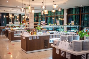 Een buffetgedeelte met meerdere aanzitellen, elk met diverse gerechten en toevoegingen.