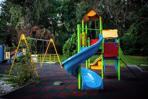A playground with a slide, swings, and a climbing structure. - Mirabelle (Varna)