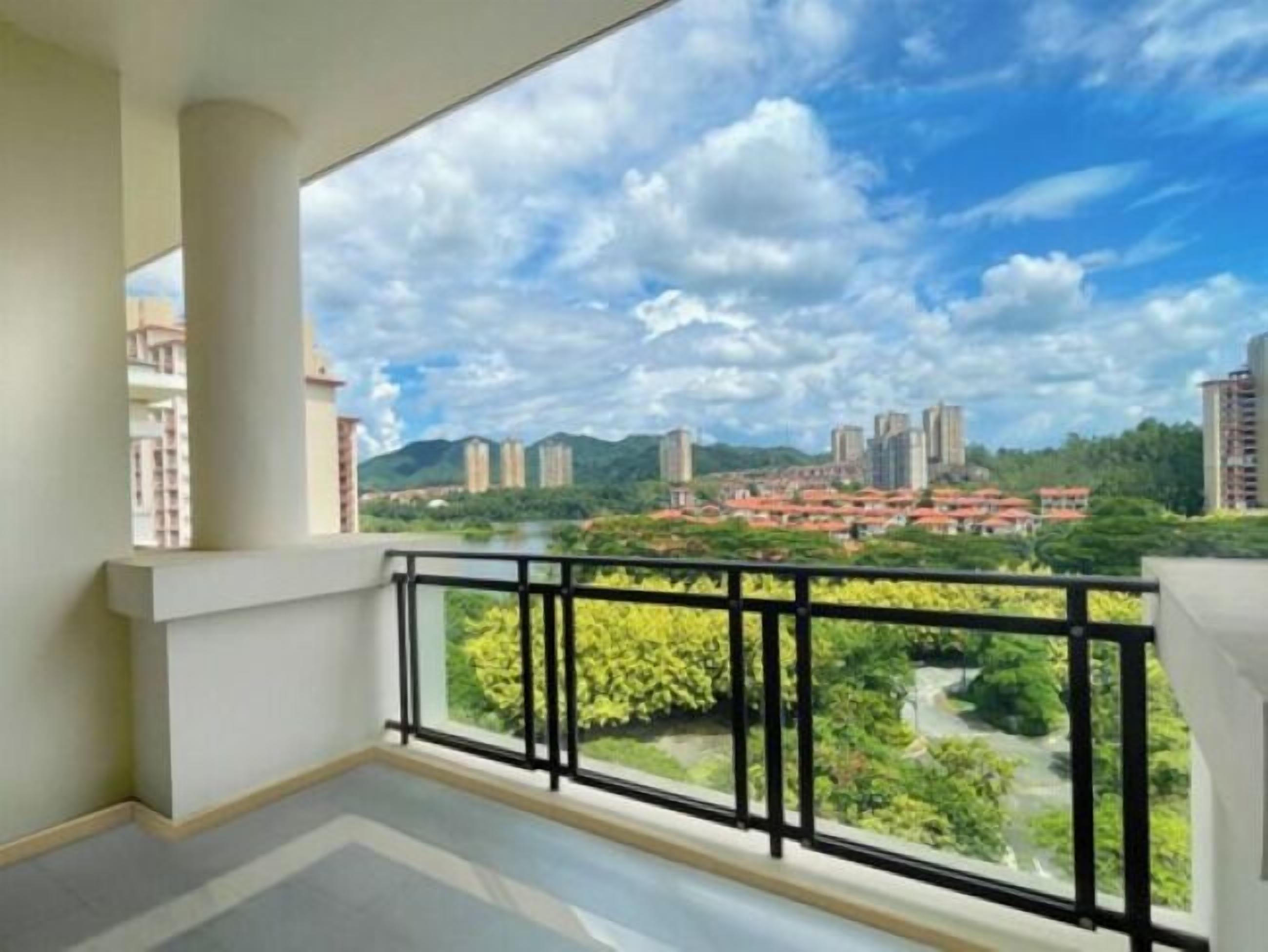 A balcony with a view of a cityscape, including buildings and greenery.