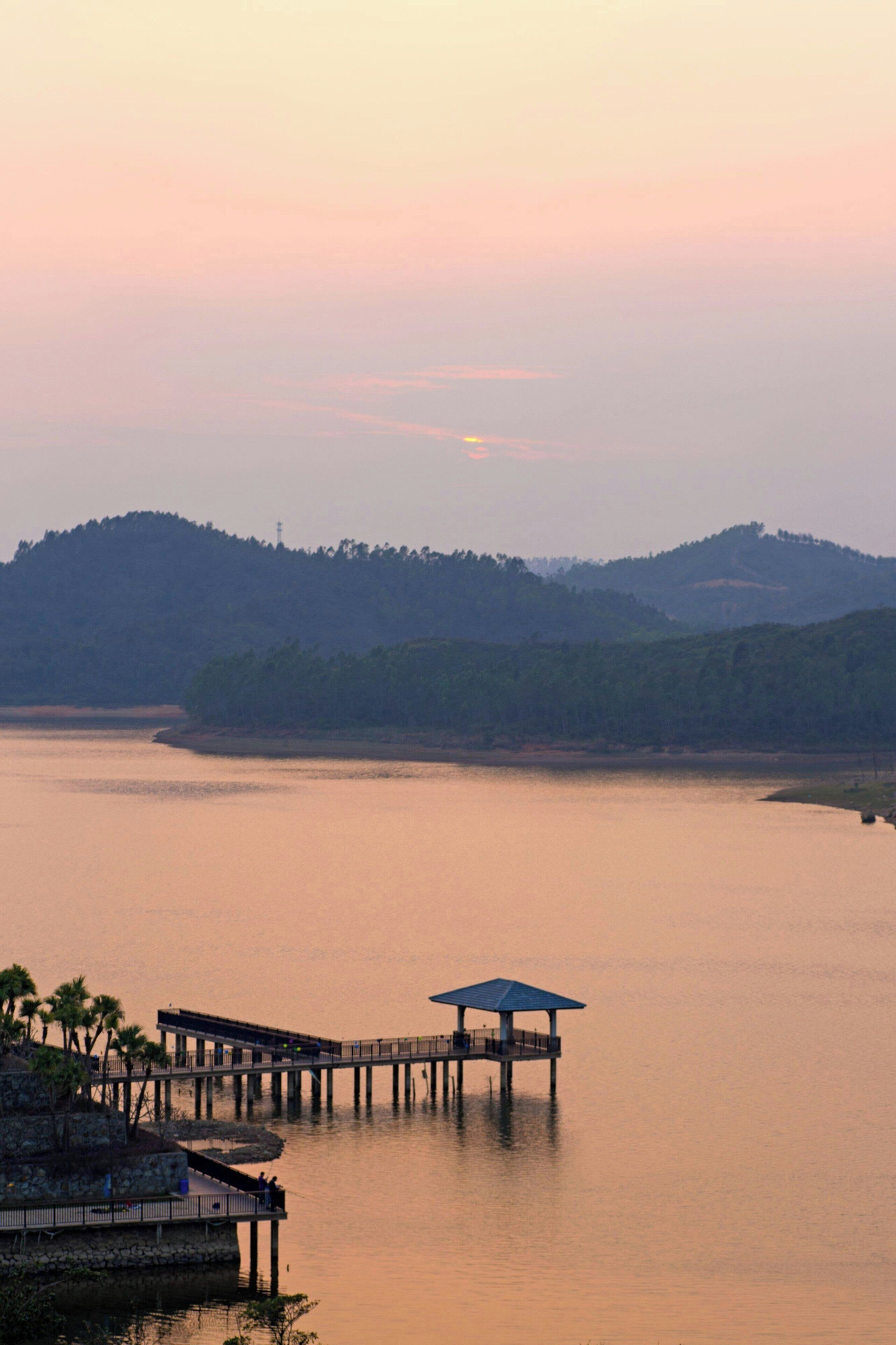 A pier extending into calm water with a gazebo at the end.