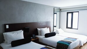 A hotel room with two beds, a nightstand with a phone, and a large mirror. - Hotel DC Feria (Bogotá)