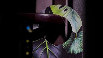 A phone with a tropical leaf design and text reading "Favor NO molestar. Please do not disturb. DC Feria Hotel."