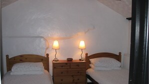 A bedroom with two beds, a wooden dresser, and two bedside lamps. - The Woodlands (Ely)