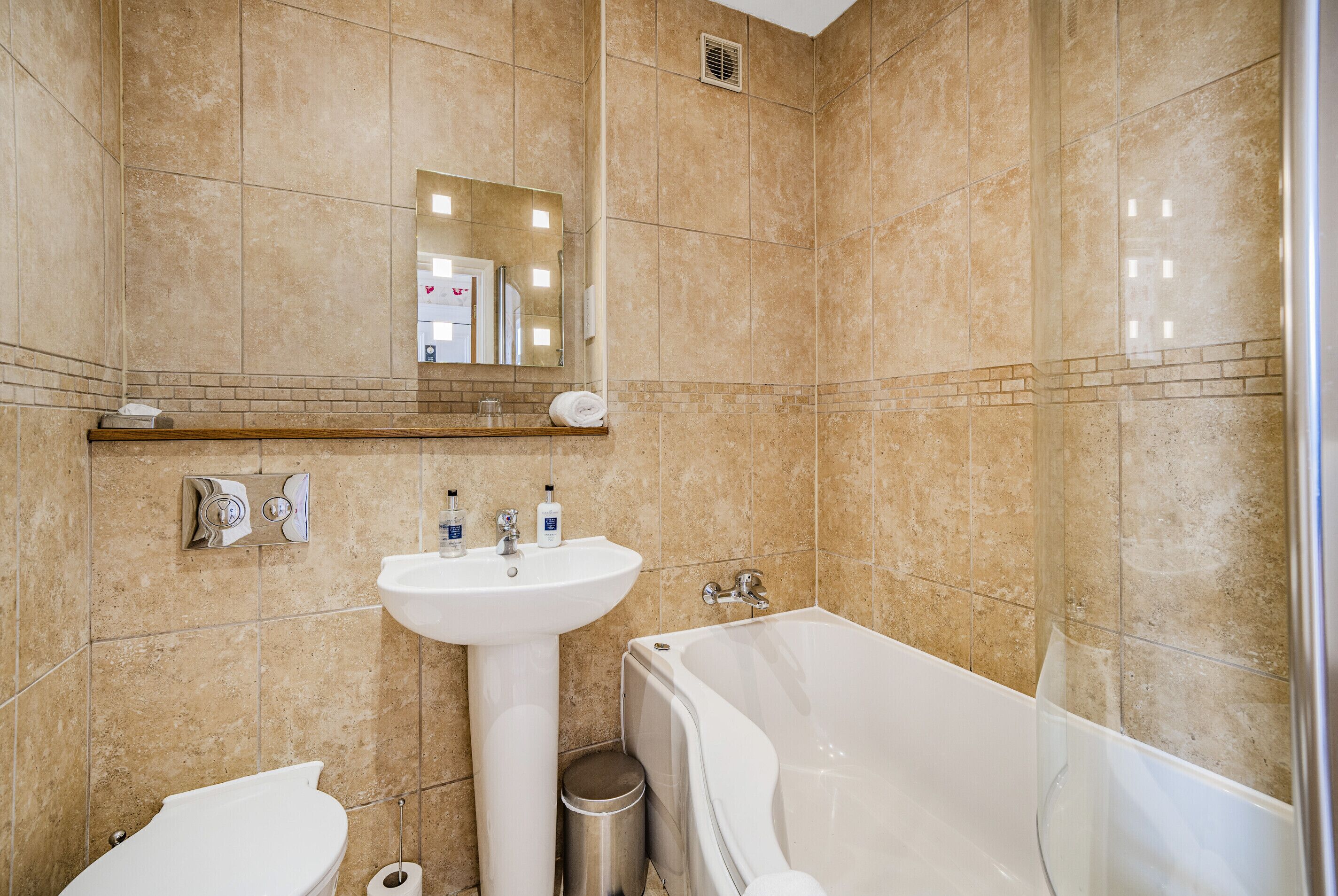 Ein Badezimmer mit Waschbecken, Spiegel und Badewanne.