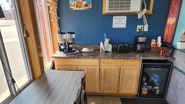Eine kleine Küchenzeile mit Kaffeemaschine, Toaster und Kühlschrank.