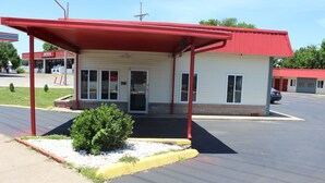 Ein kleines, einstöckiges Motel mit rotem Dach und einer überdachten Veranda.