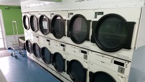 Reihe von Industrie-Waschmaschinen in einer gewerblichen Umgebung.